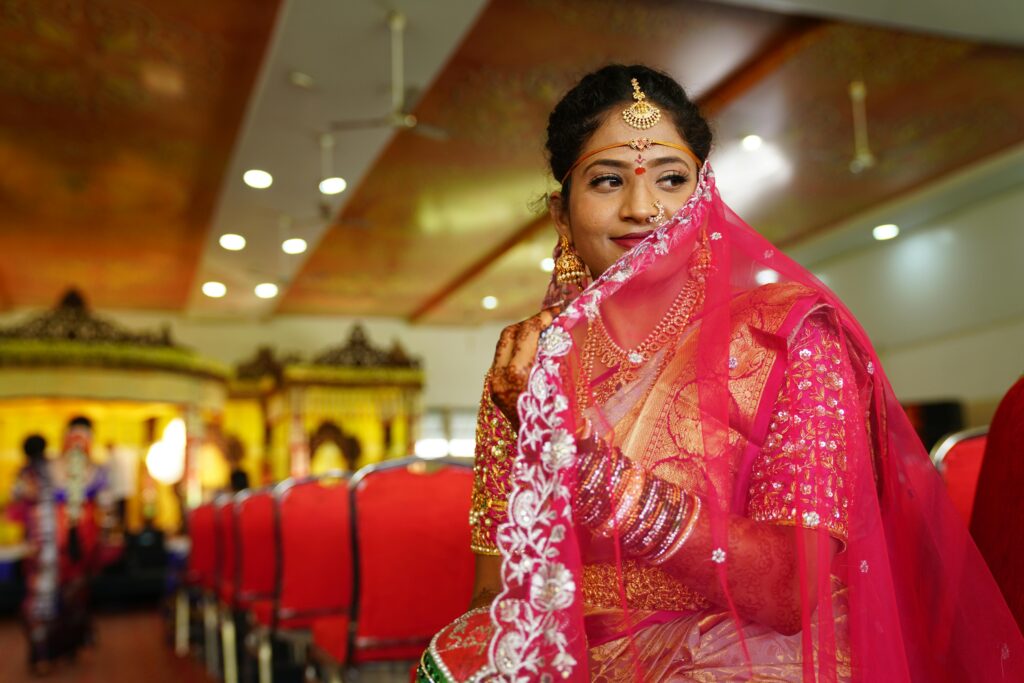 Beautiful Indian bride wearing traditional attire and jewelry, captured indoors at a wedding in Hyderabad.