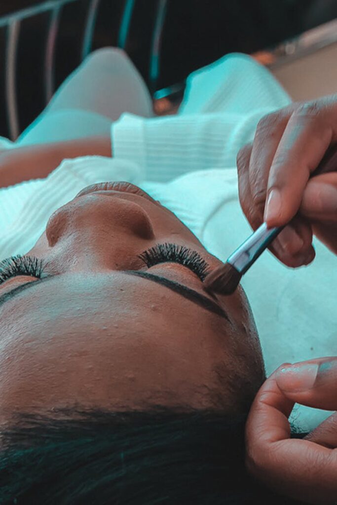 Close-up of a professional makeup artist applying eye makeup in a salon setting.