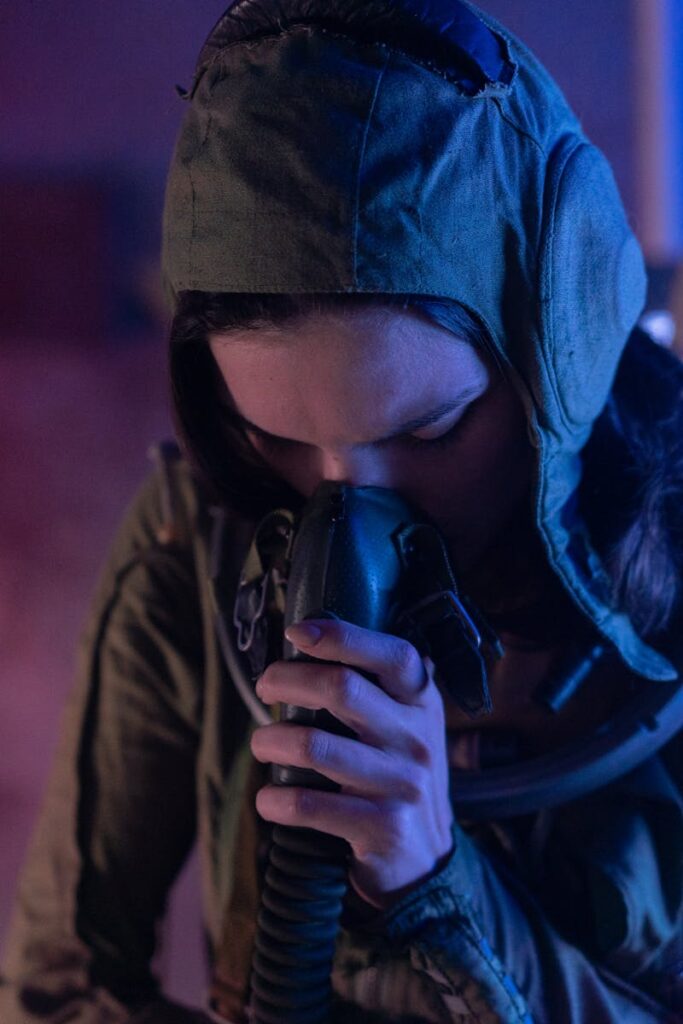 A woman in a space suit using an oxygen mask in a sci-fi setting.
